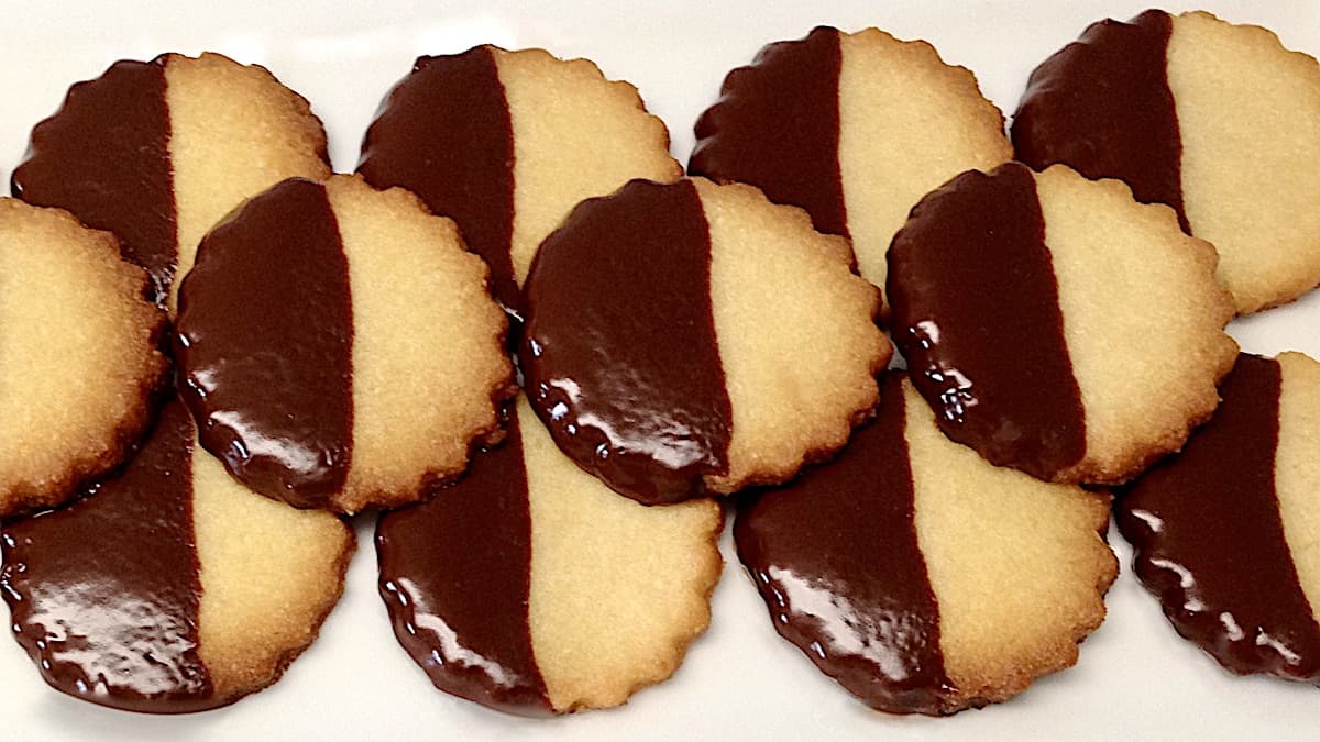 closeup of Keto Chocolate Dipped Shortbread Cookies lined up on white plate