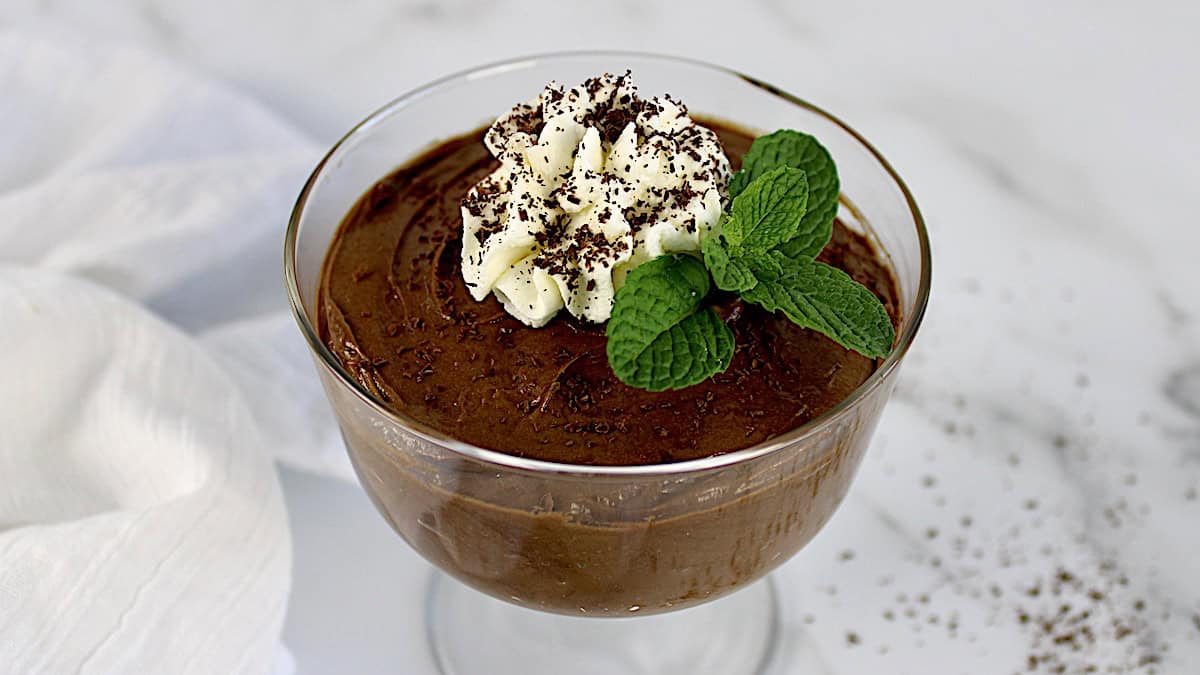 Keto Chocolate Pudding in glass with whip cream and mint leaf on top