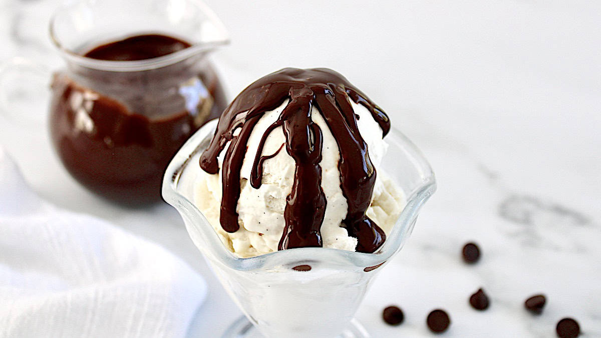 Keto Chocolate Sauce dripping over vanilla ice cream in glass