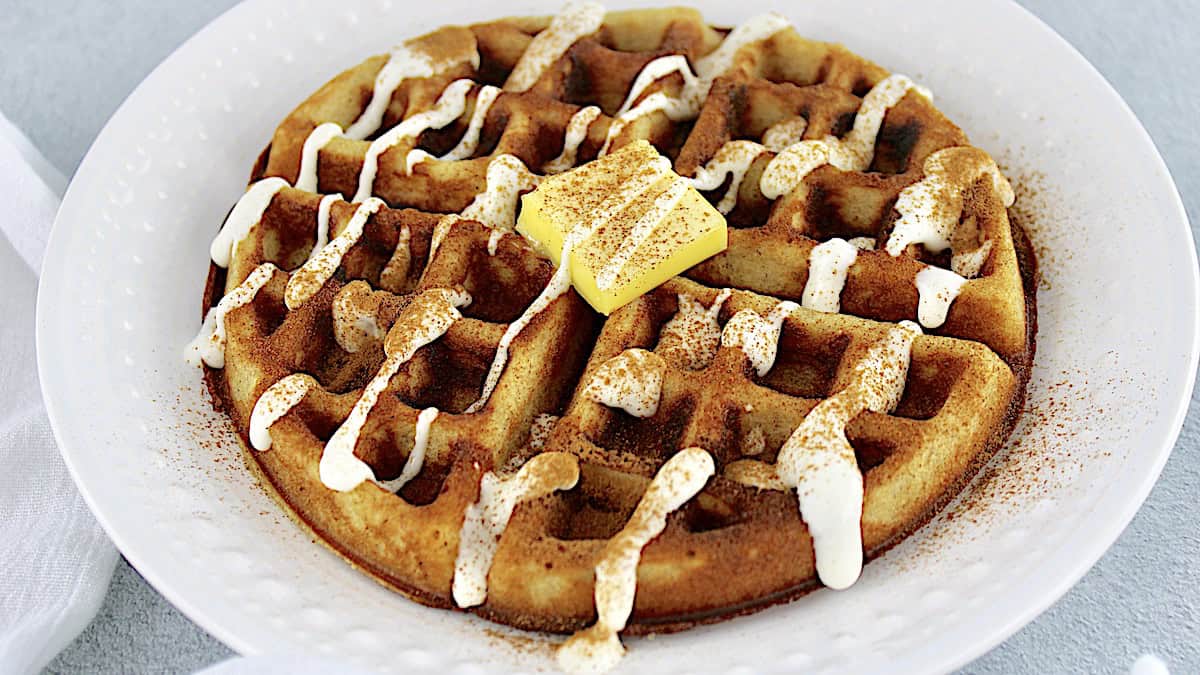 Keto Cinnamon Roll Waffle with icing on top and pad of butter in the center