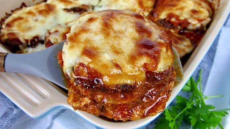 eggplant parmesan being spooned out of a casserole