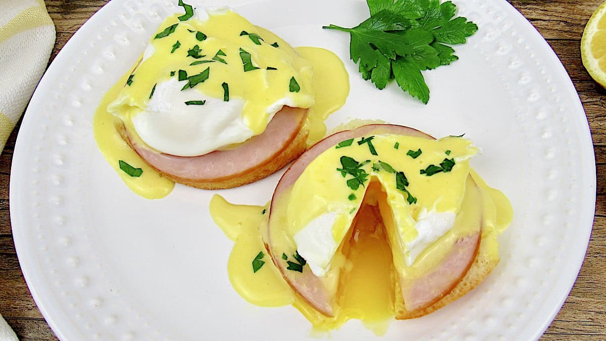 Keto Eggs Benedict on white plate with parsley