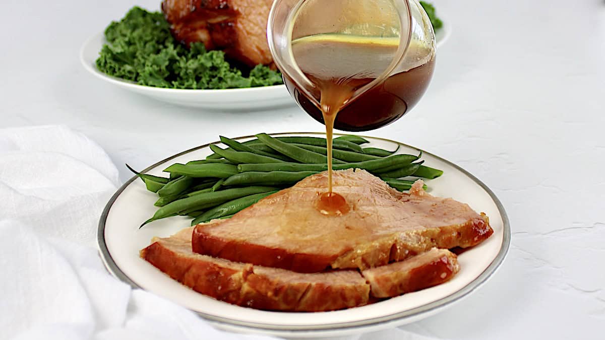 Keto Glazed Ham with gravy being poured over top