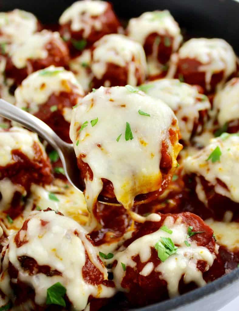 closeup of Keto Italian Meatball in spoon with cheese pull