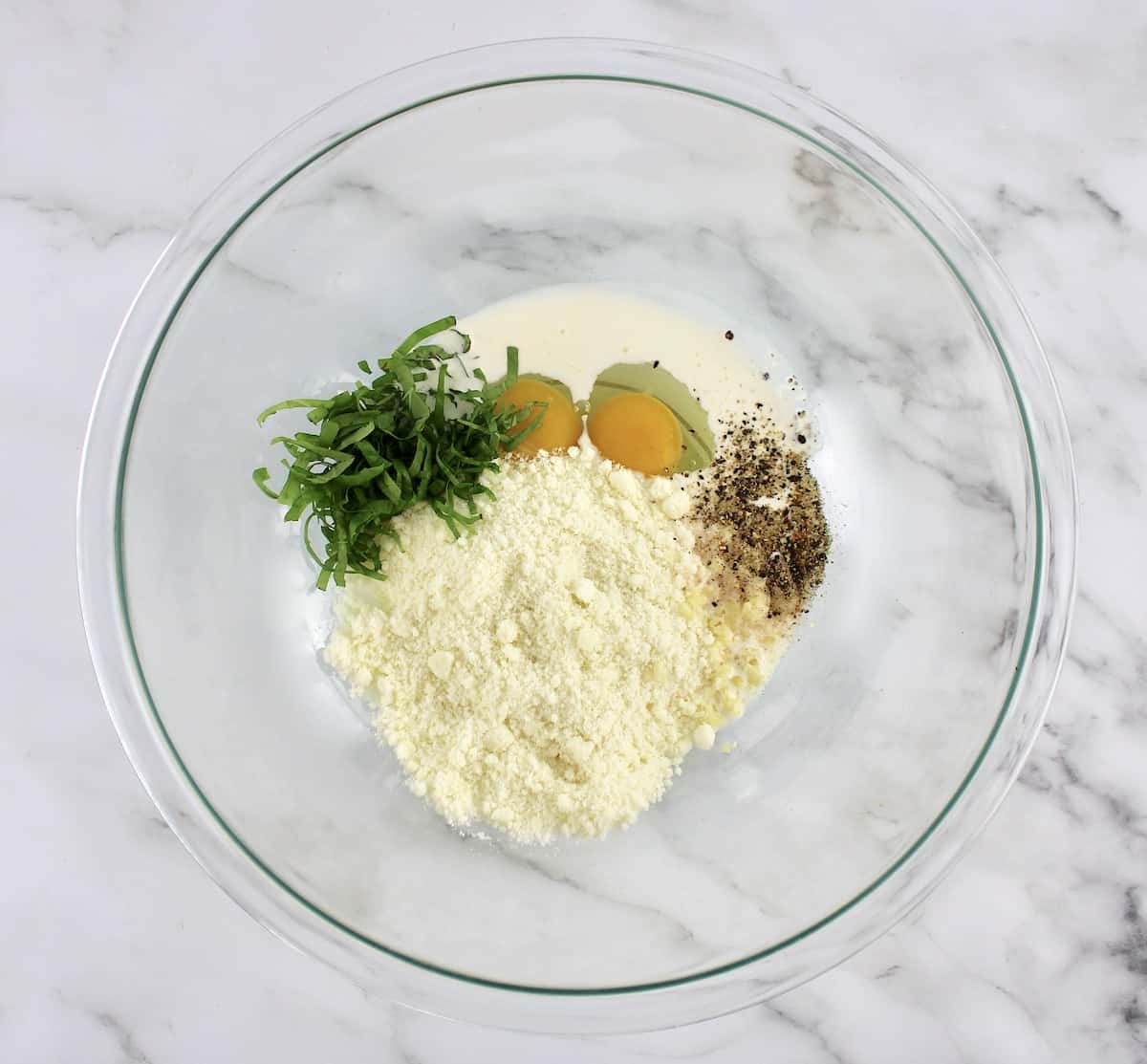 cheese, eggs, basil and cream in mixing bowl unmixed