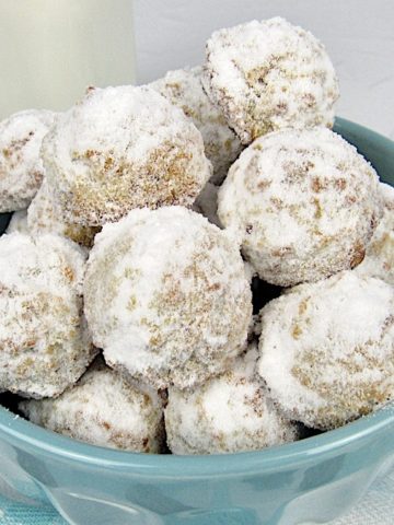 Keto Maple Pecan Snowball Cookies in teal bowl with milk in background