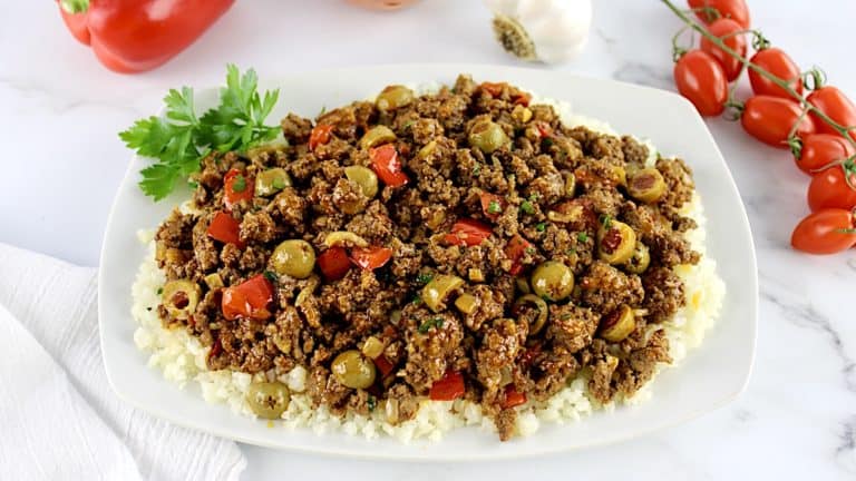 Keto picadillo over cauliflower rice on white plate with parsley garnish