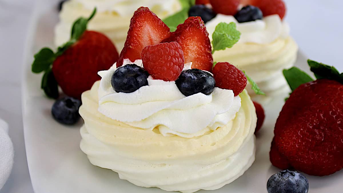 closeup of Mini Pavlova with whip cream and berries on top