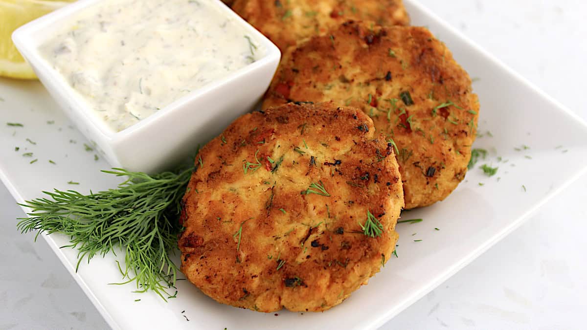 closeup of Salmon Patties with dill sauce on side