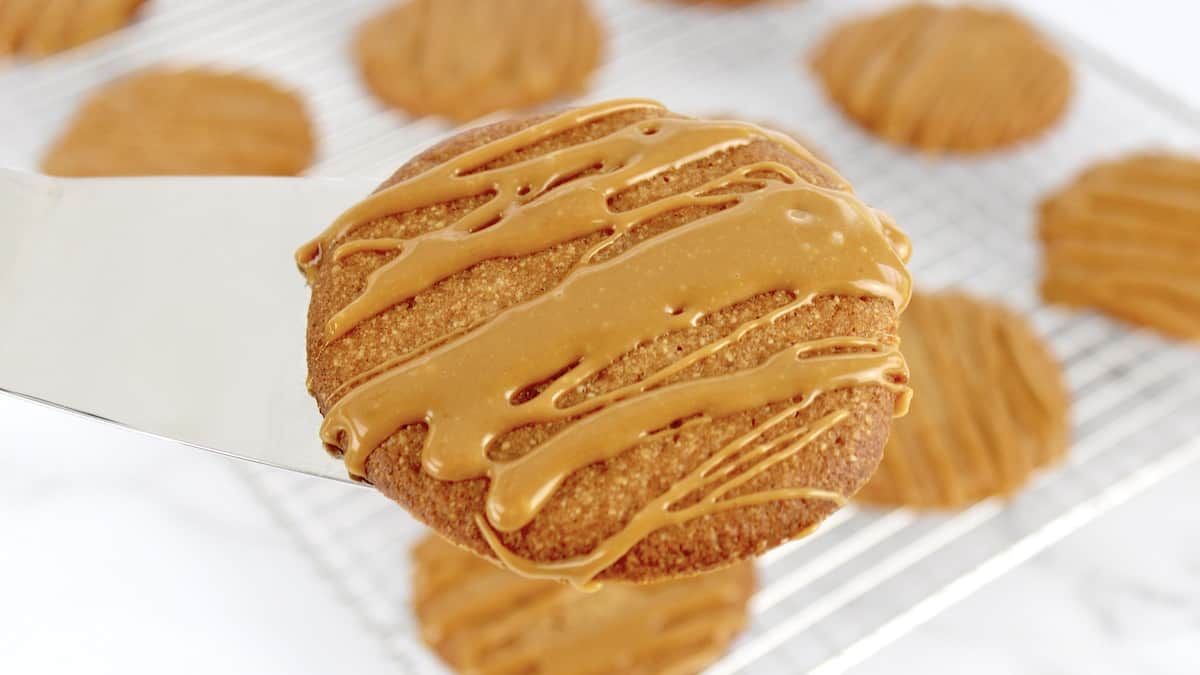 Salted Caramel Cookie on silver spatula with caramel drizzled on top