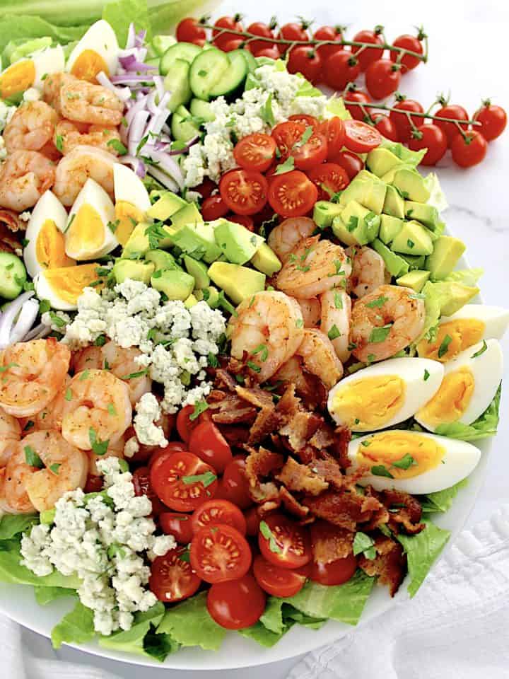 overhead view of Shrimp Cobb Salad with cherry tomatoes in background