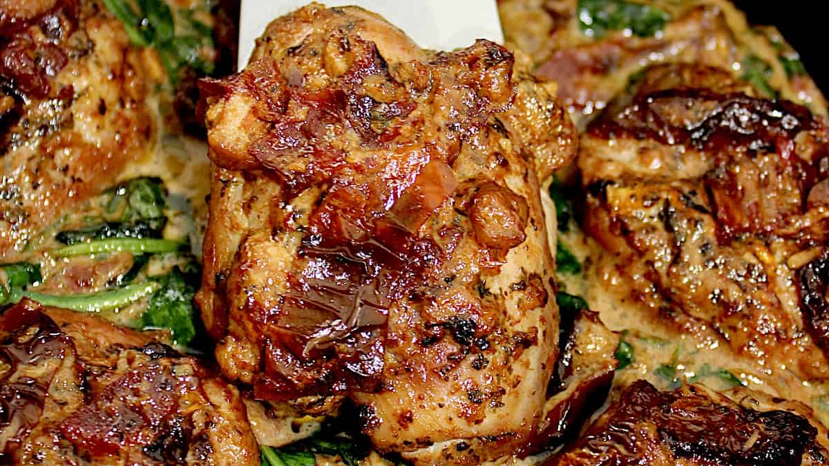 closeup of a piece of Slow Cooker Tuscan Chicken in silver spatula