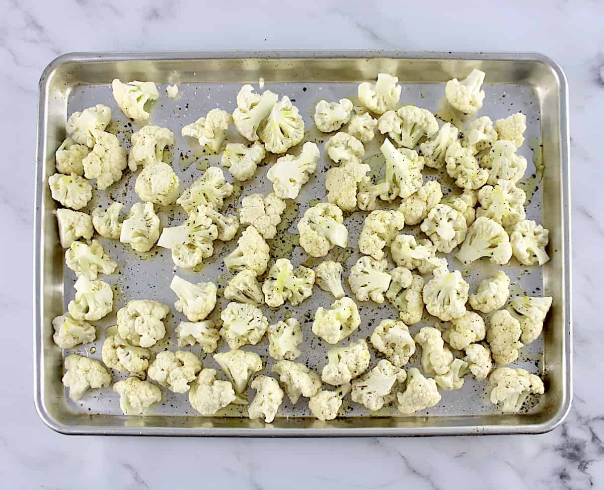 cauliflower florets on baking sheet with salt, pepper and olive oil