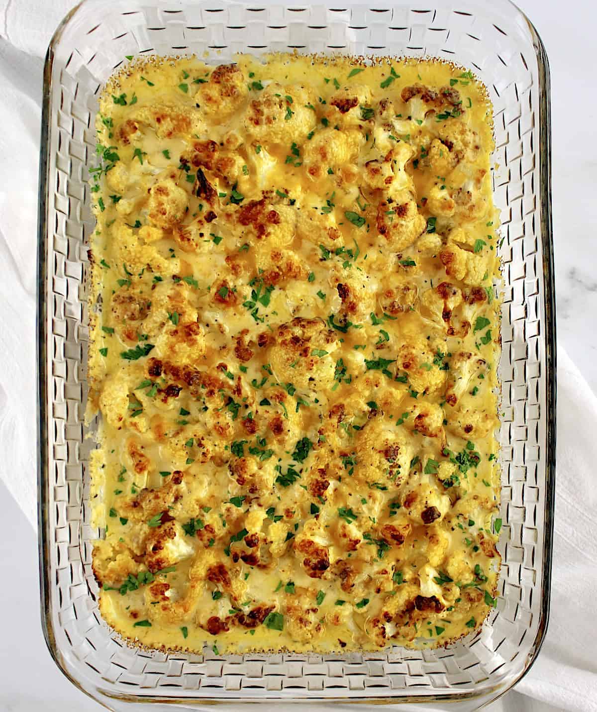 overhead view of Cheddar Roasted Cauliflower in glass casserole