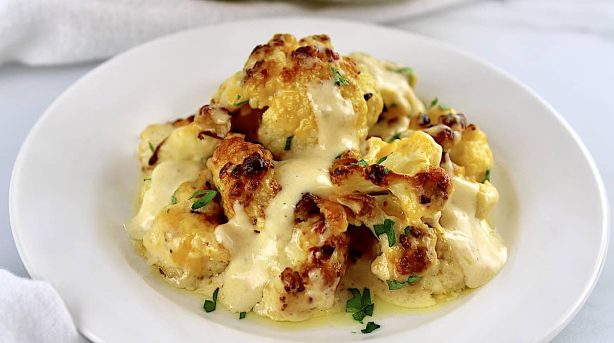 cheddar roasted cauliflower on round white dish