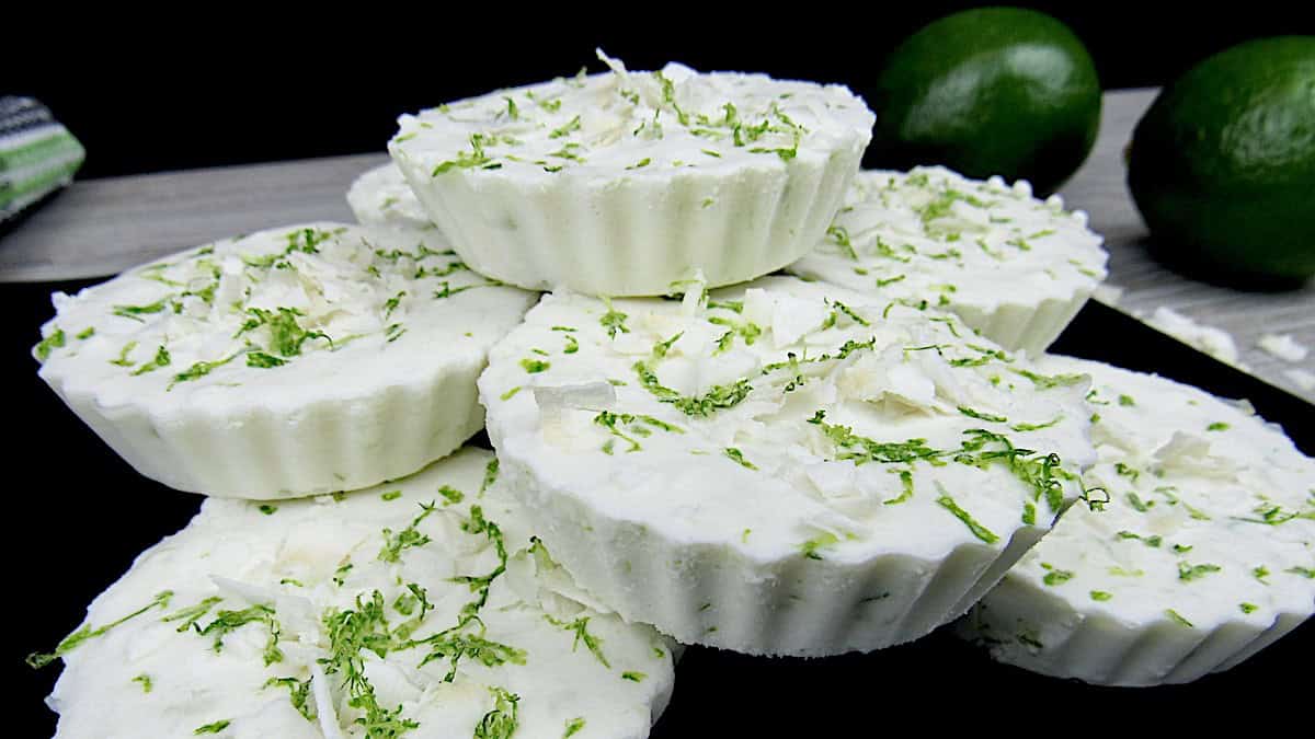 Coconut Lime Fat Bombs piled up with lime zest and flaked coconut on top