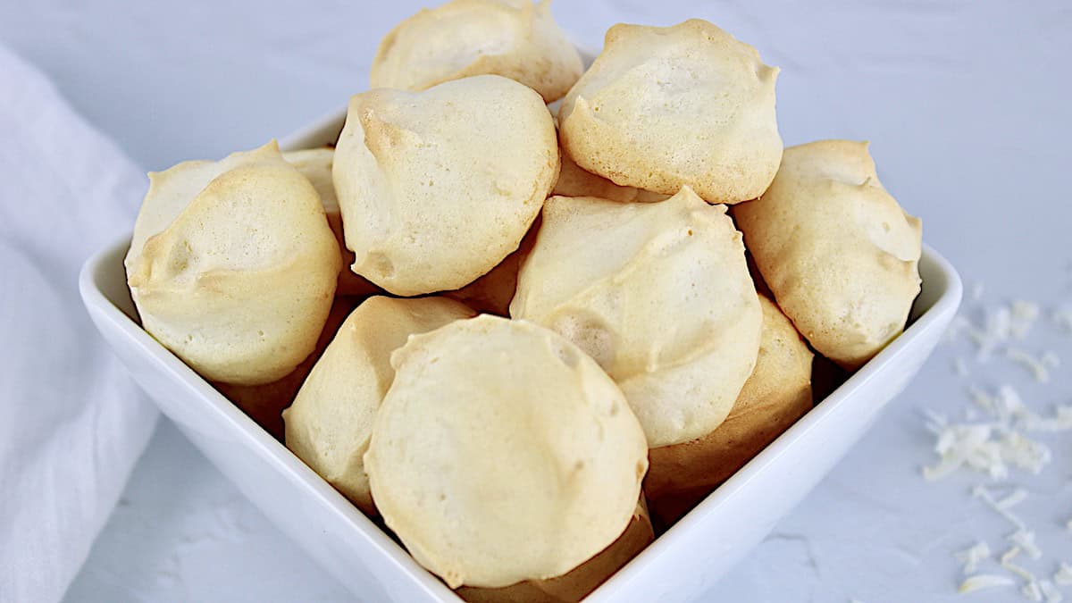 Coconut Meringue Cookies piled up in white square bowl