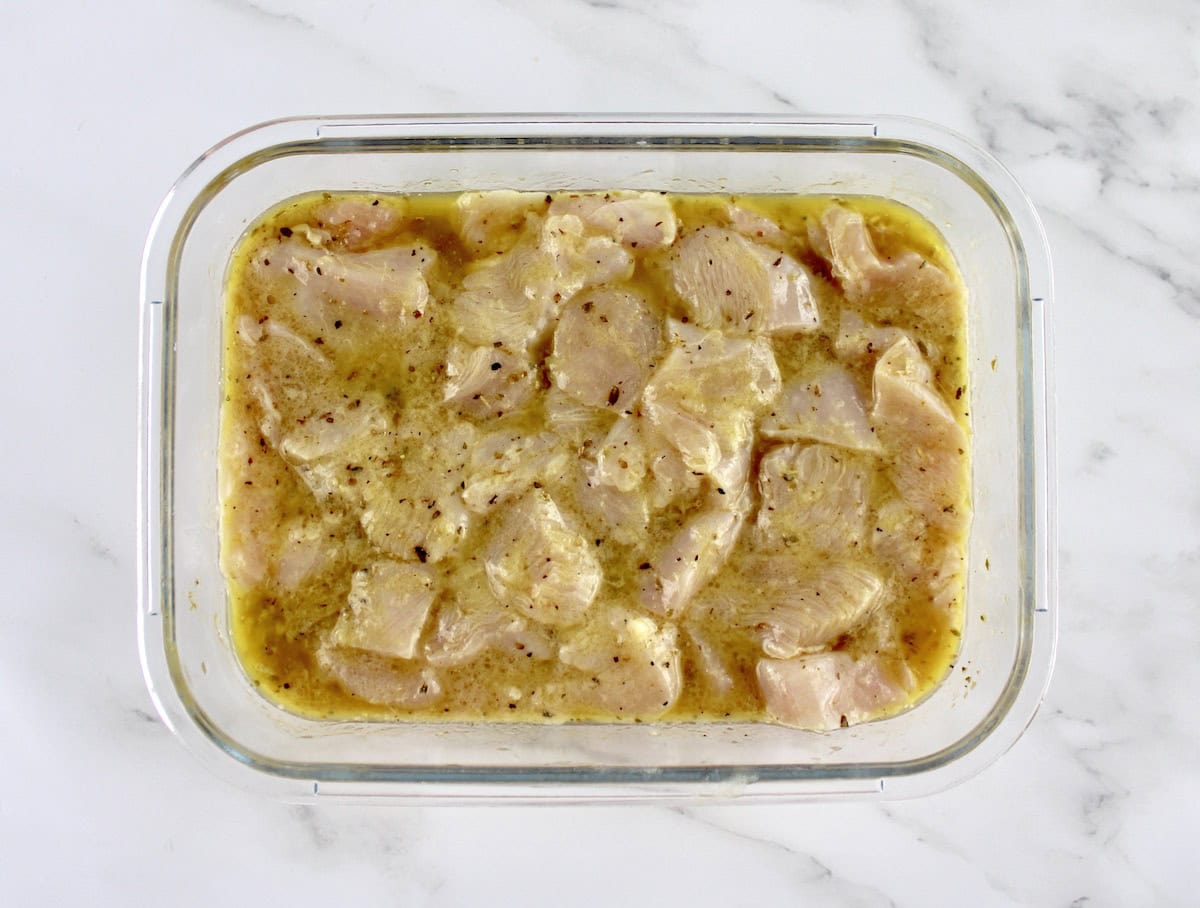 marinated chunks of chicken in glass container