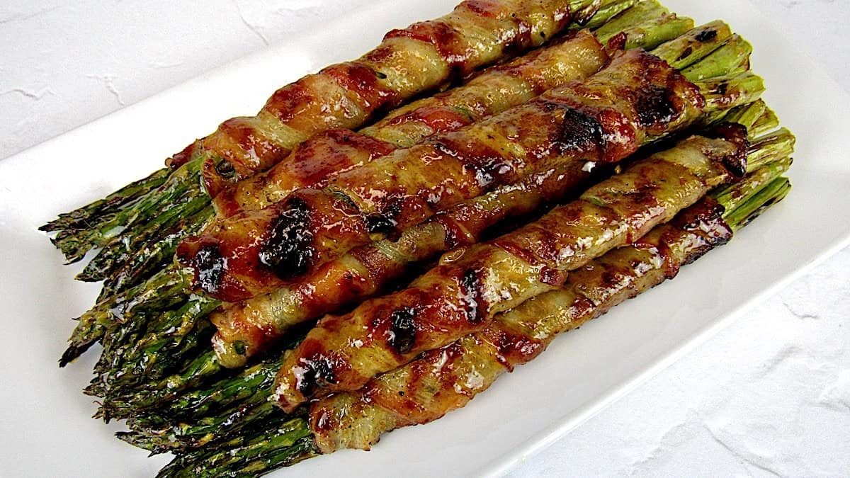 Grilled Bacon Wrapped Asparagus on white plate