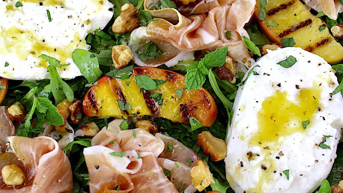 Grilled Peach Burrata Salad with Prosciutto and dressing drizzled on top