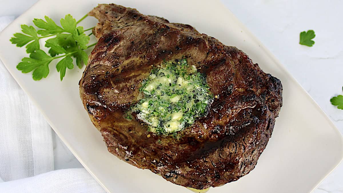 grilled ribeye steak with pad of compound butter on top