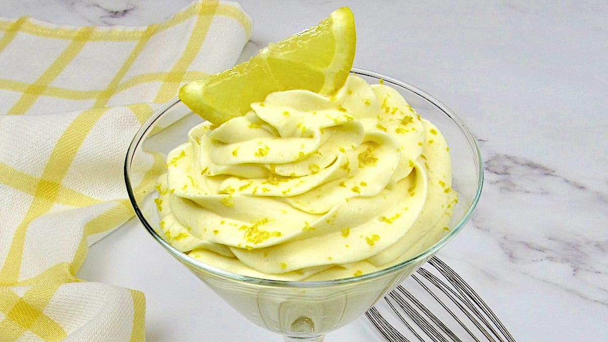 Lemon Cheesecake Mousse in glass with lemon zest and lemon slice on top