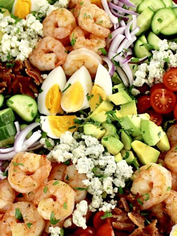 overhead closeup view of Shrimp Cobb Salad with cherry tomatoes in background