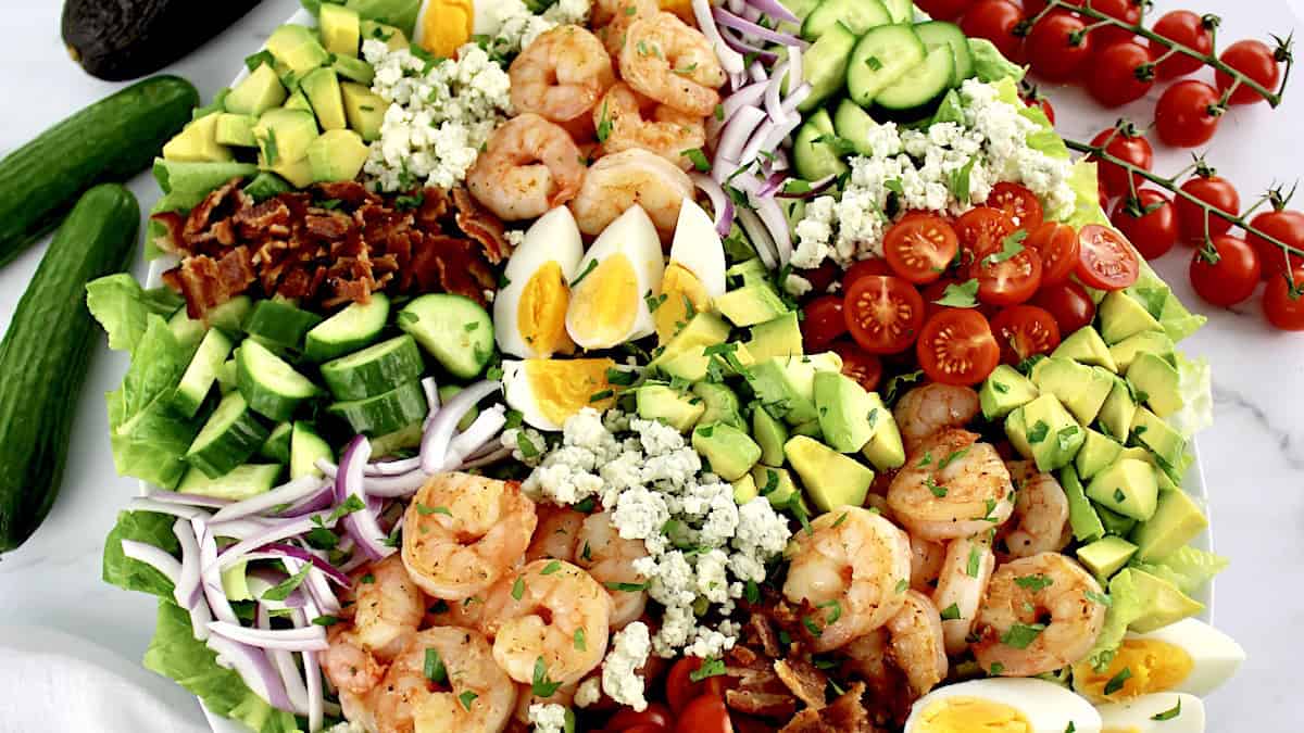 overhead closeup view of Shrimp Cobb Salad with cherry tomatoes in background