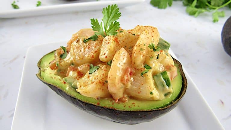 closeup shrimp salad in 1/2 avocado with cilantro in background