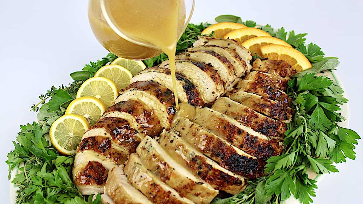 Slow Cooker Turkey Breast sliced on platter with gravy being poured over