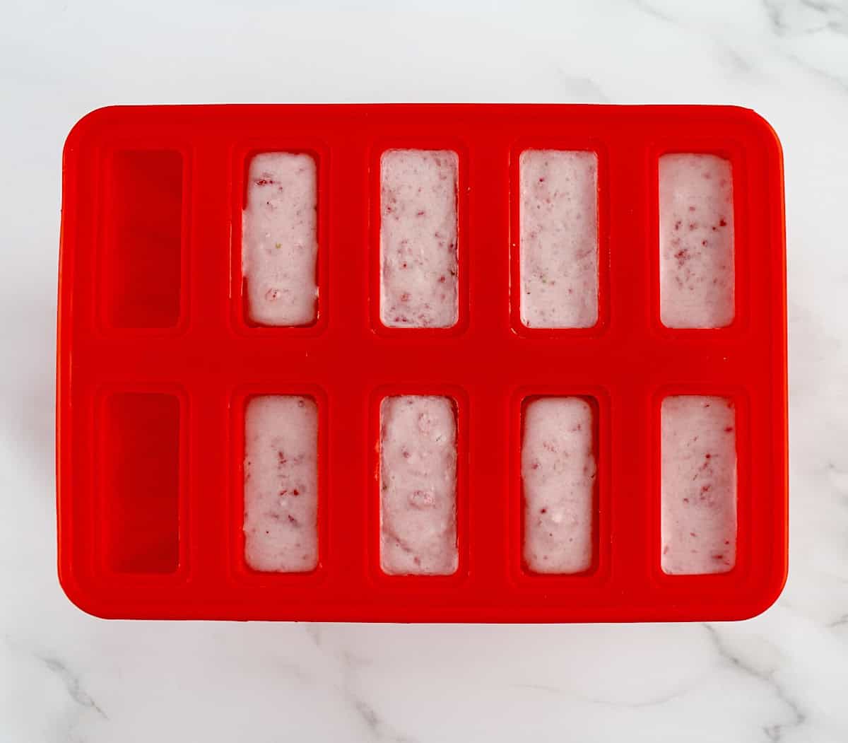 Strawberry Coconut Cream Popsicles mixture in 8 popsicles molds