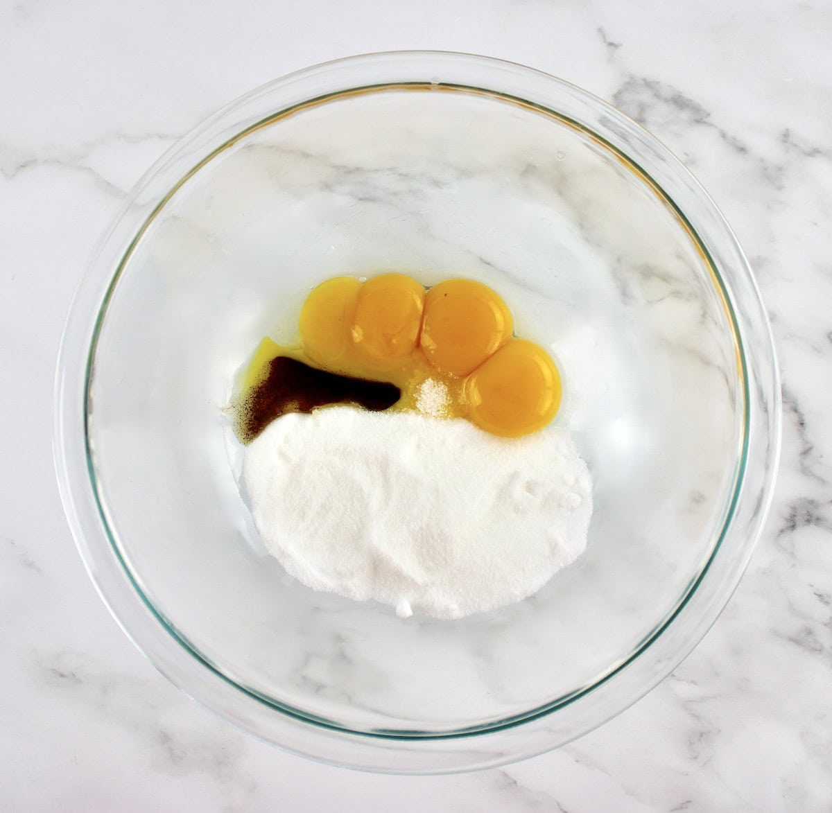 4 egg yolks, sweetener and vanilla bean paste in glass bowl