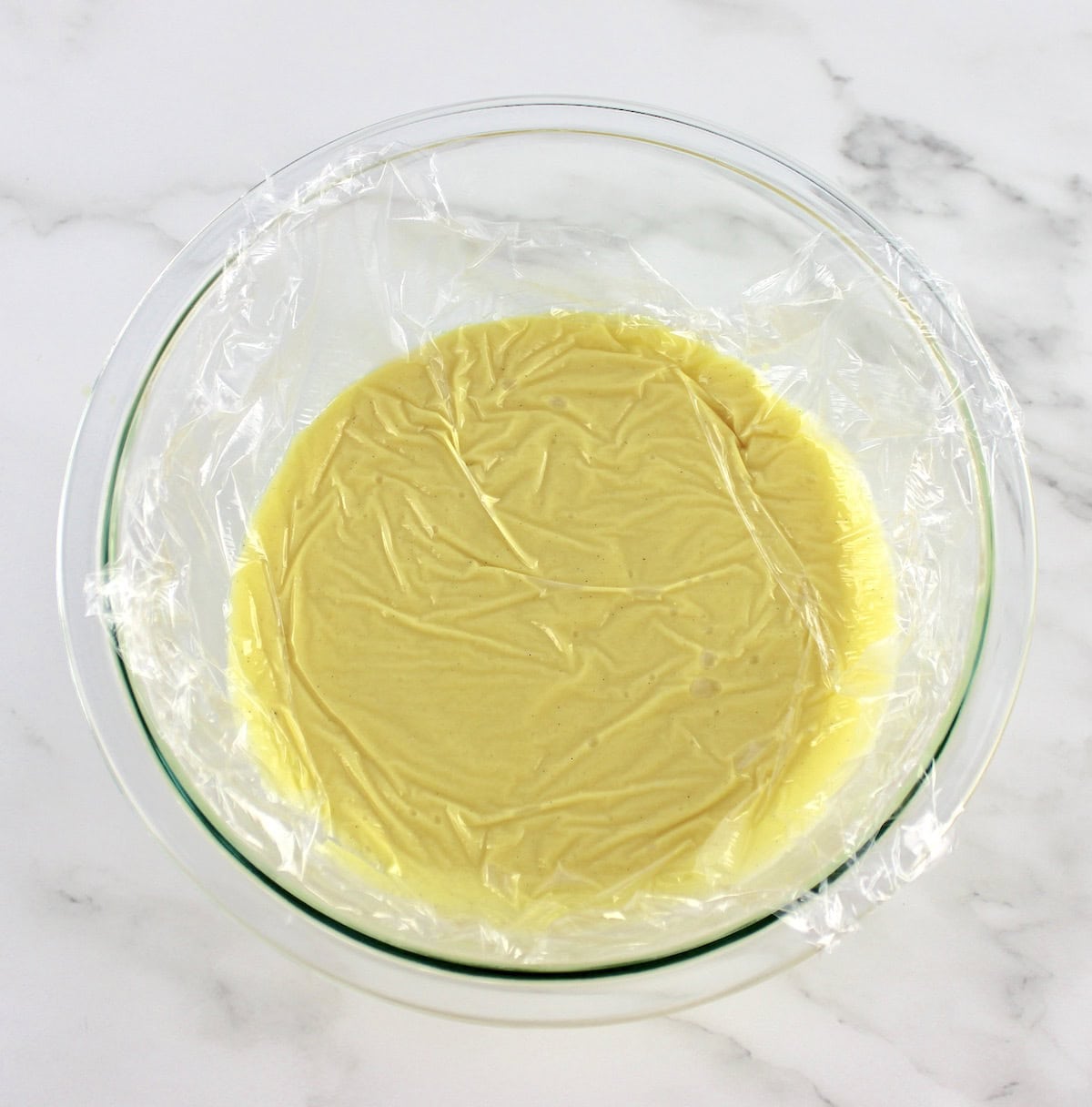 Sugar Free Keto Custard in glass bowl with plastic wrap touching the top