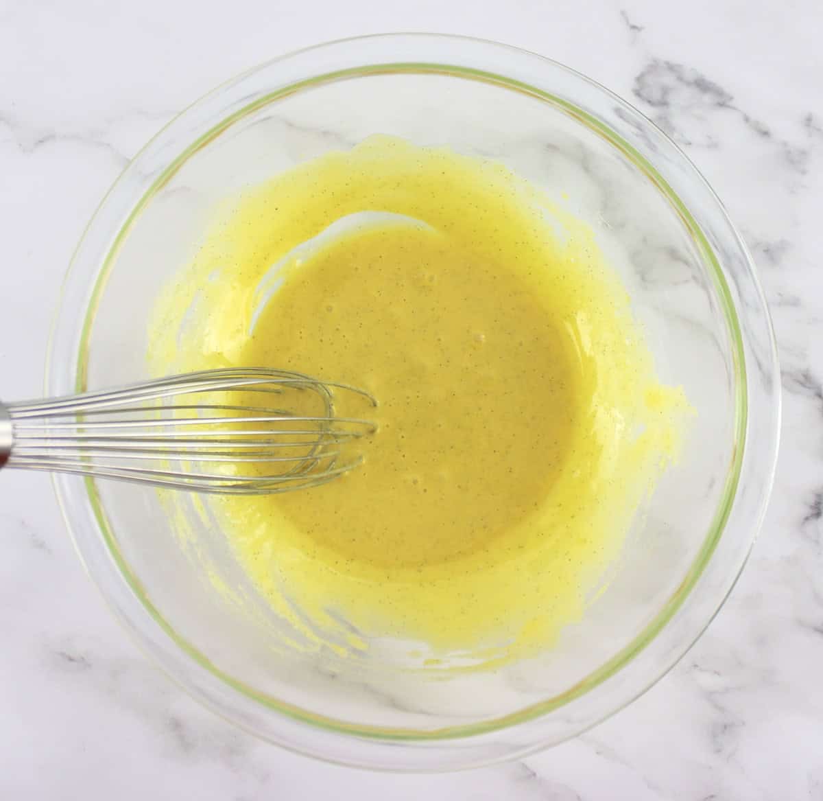 egg yolks and sweetener in glass bowl being whisked