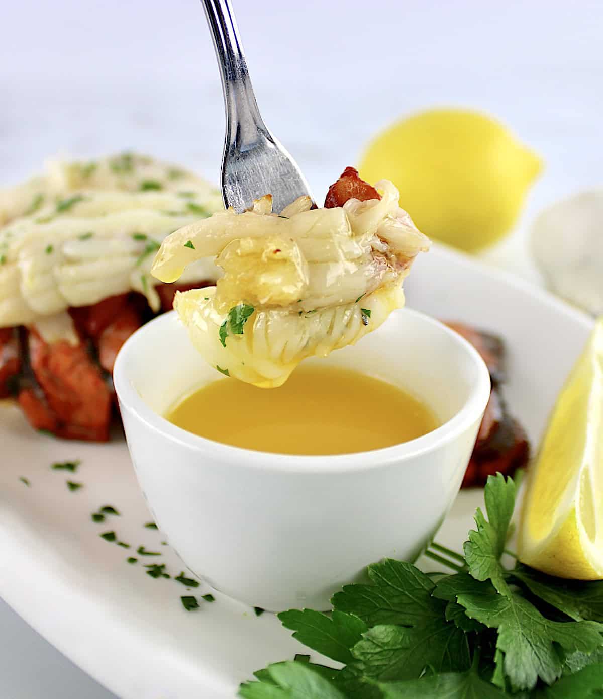 lobster meat on fork dipped into melted butter