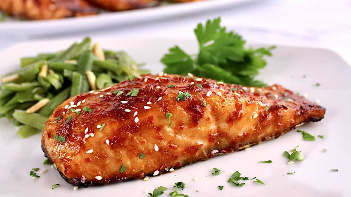 closeup of Asian Glazed Salmon on white plate with chopped parsley