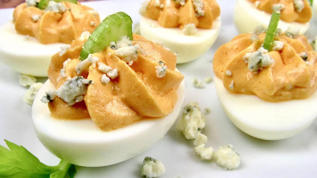 Buffalo Deviled Eggs with celery and blue cheese on top