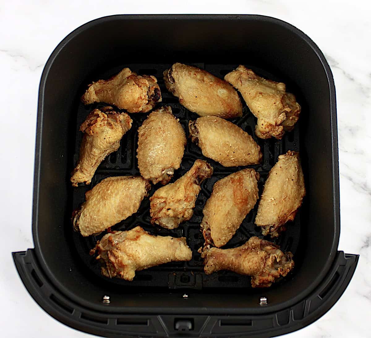 12 crispy chicken wings in air fryer basket