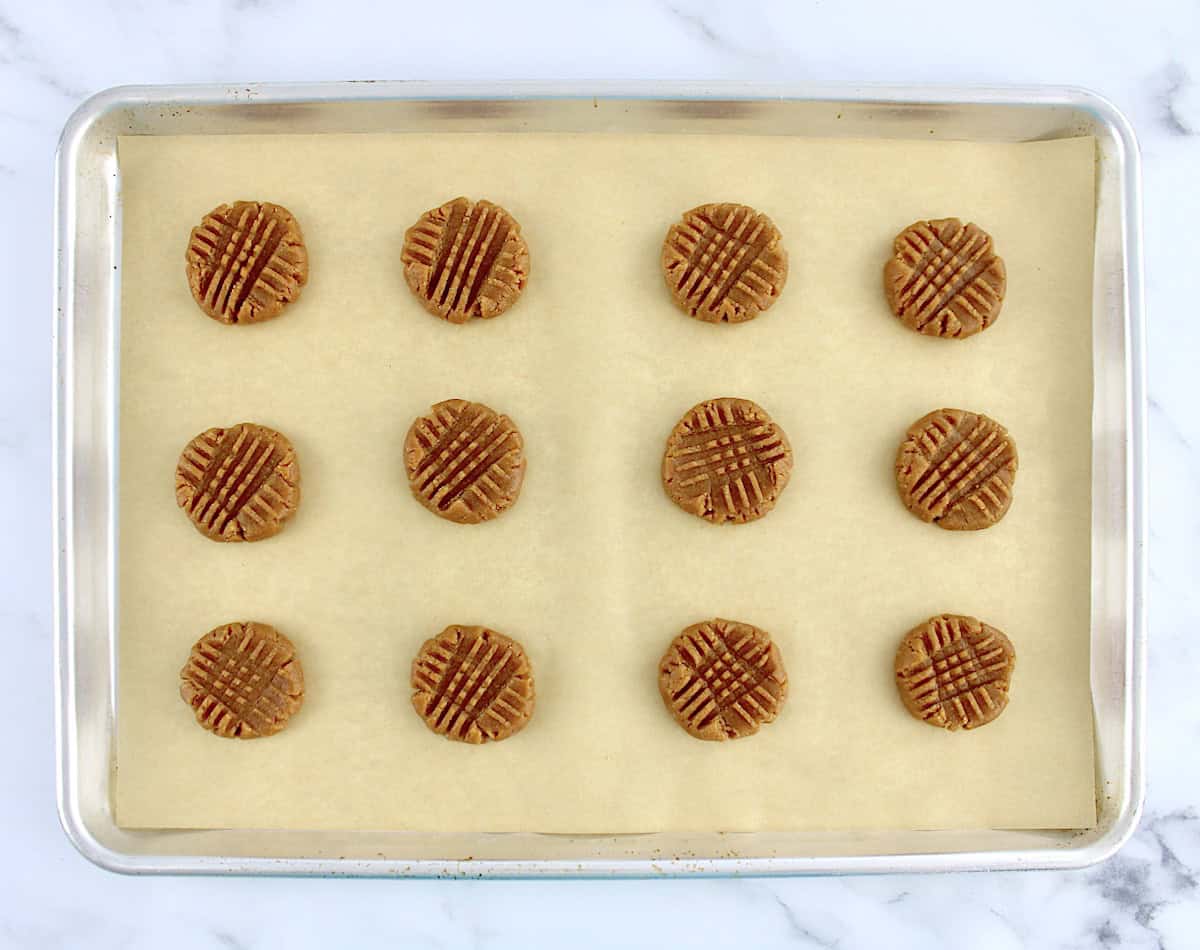 12 Easy Peanut Butter Cookies on baking sheet with parchment paper unbaked