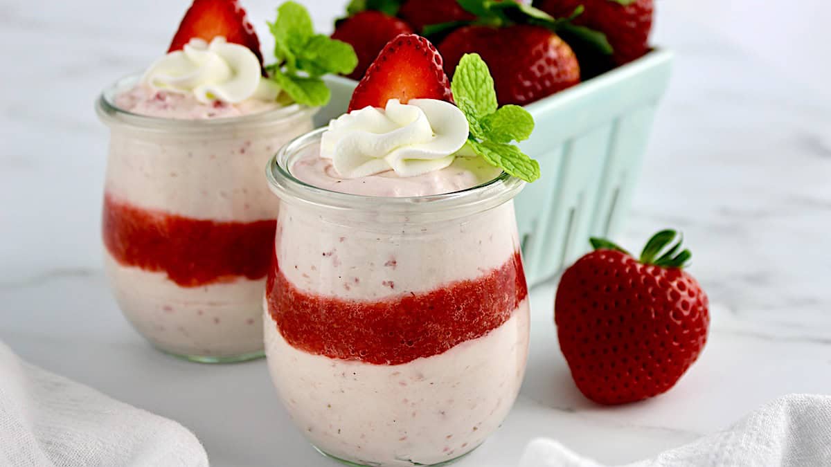 Easy Strawberry Mousse in glass jar with whip cream and mint on top