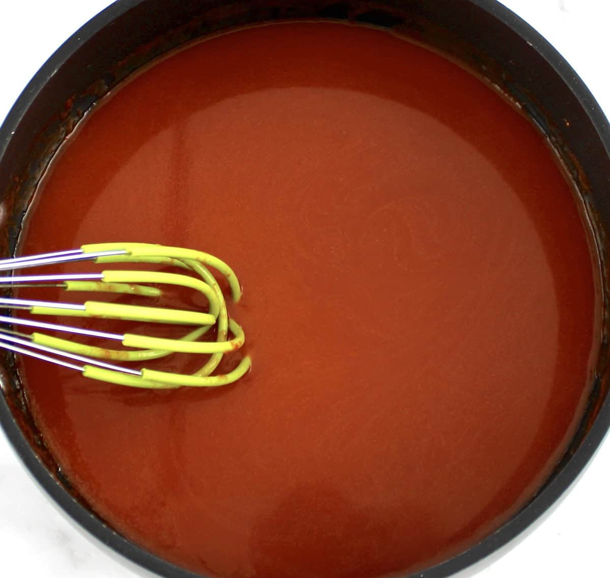 Homemade Buffalo Wing Sauce in saucepan with whisk