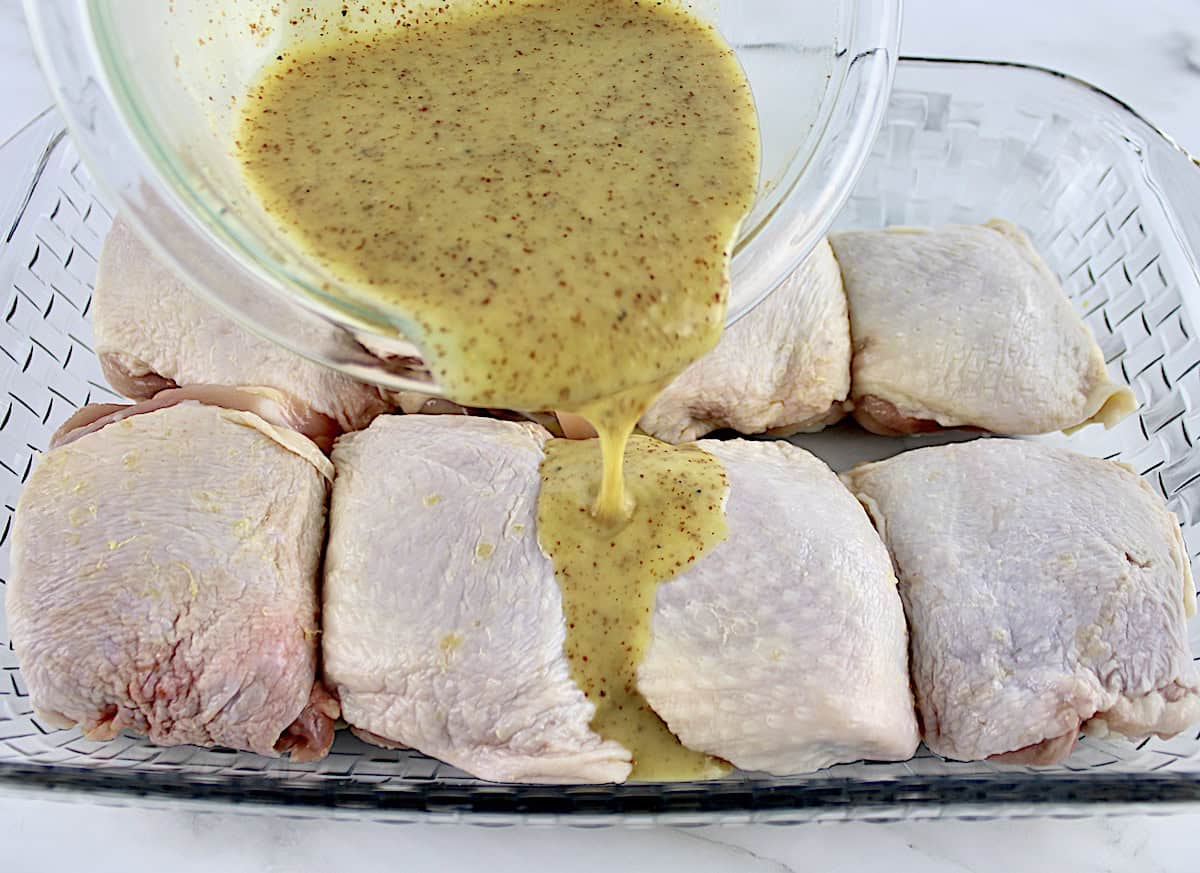 chicken thighs with honey mustard sauce being poured over top