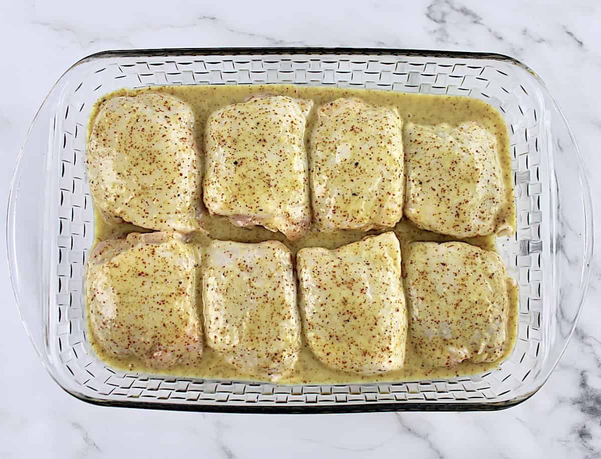 8 chicken thighs in glass baking dish marinating in honey mustard sauce