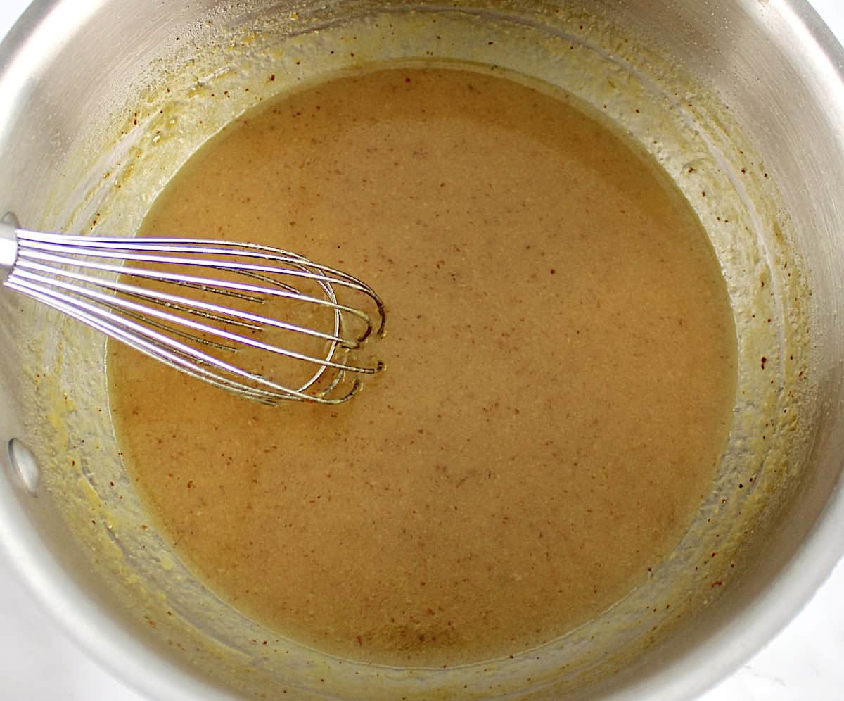 honey mustard sauce in saucepan with whisk