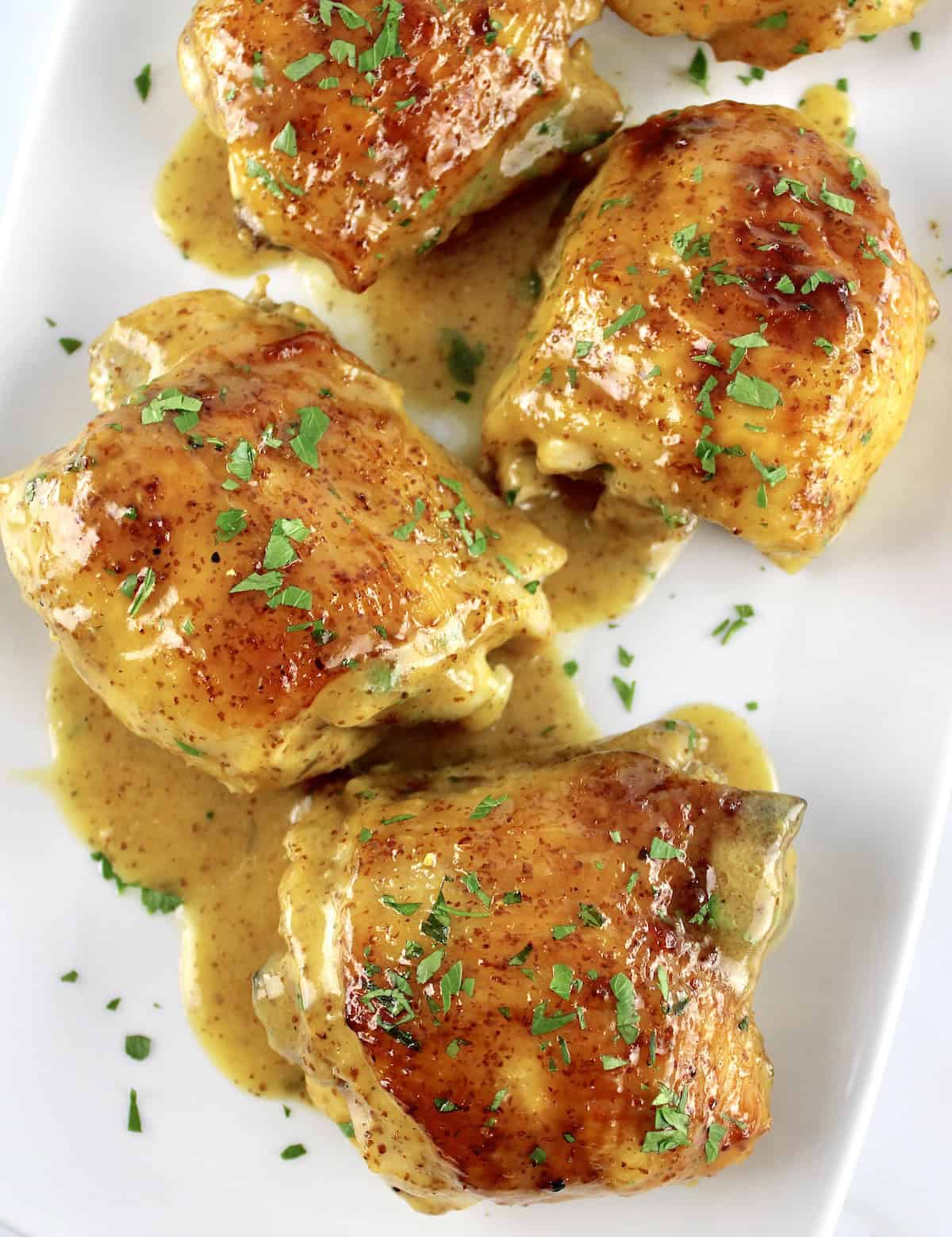 overhead view of Honey Mustard Baked Chicken Thighs on white plate