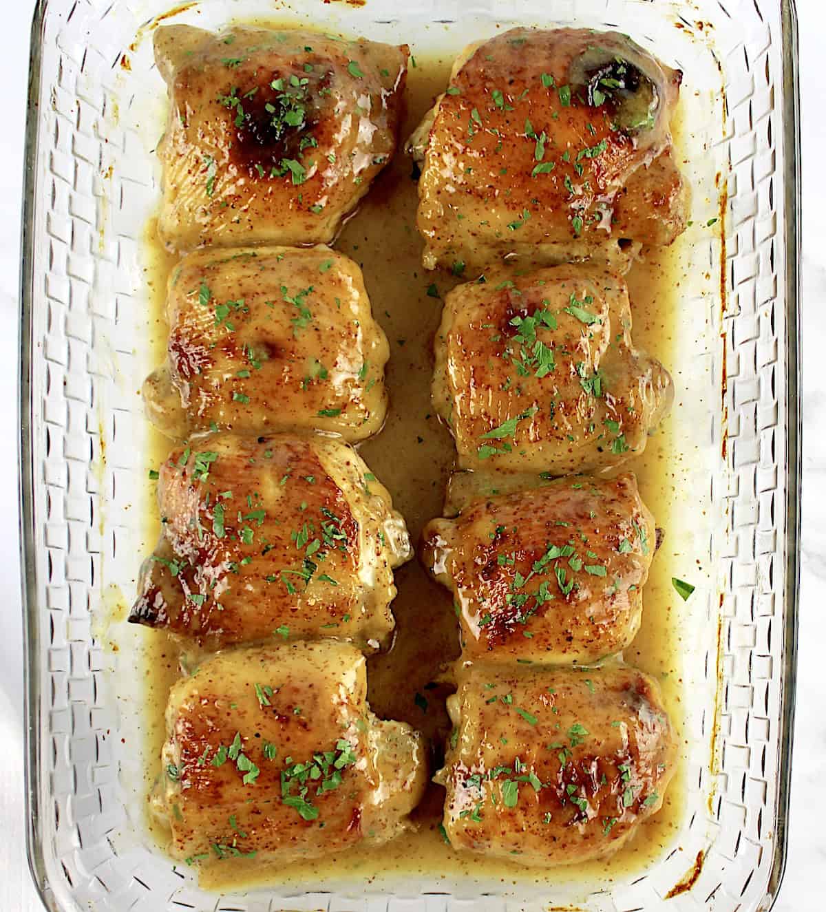 overhead view of 8 Honey Mustard Baked Chicken Thighs in glass casserole baking dish