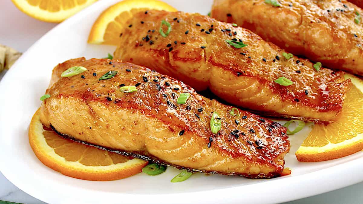 Orange Glazed Salmon on white plate with orange slices