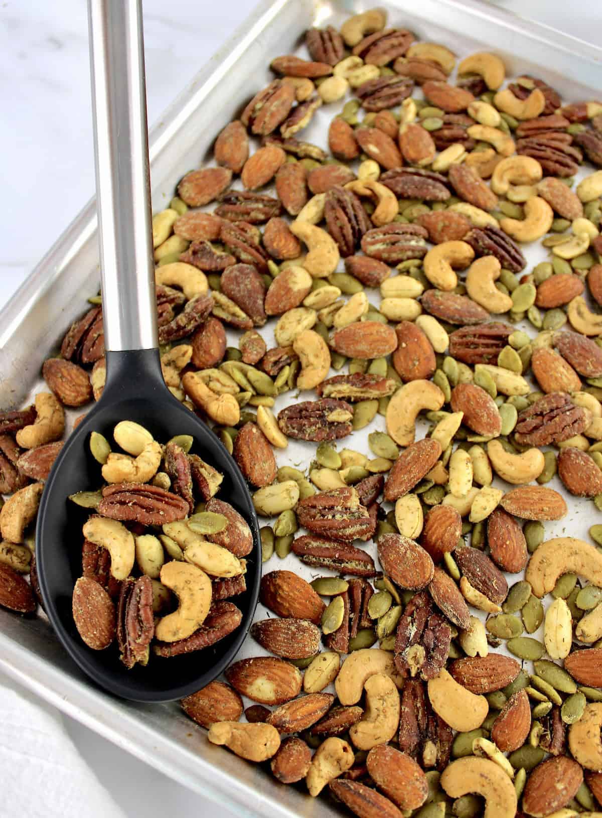 Ranch Roasted Nuts on baking sheet with black serving spoon