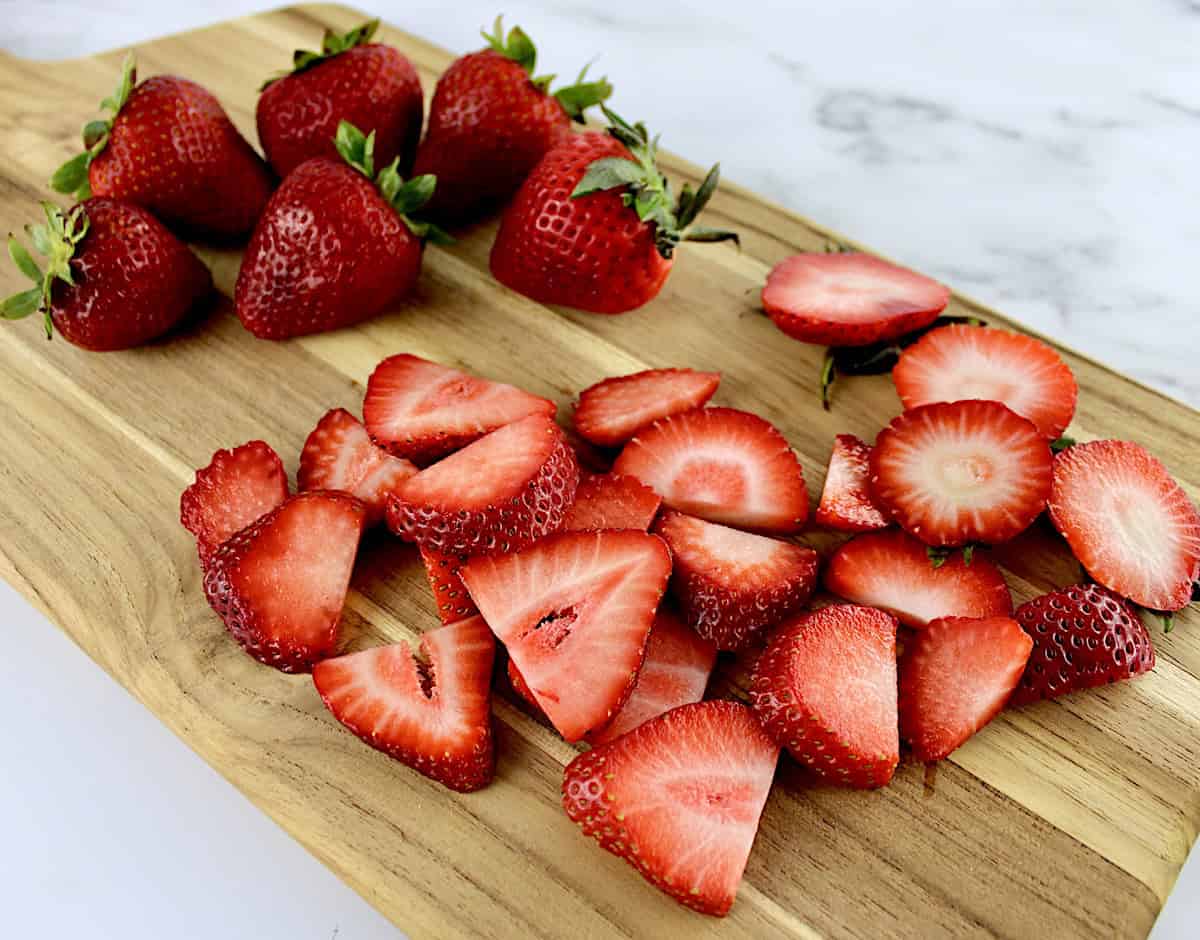 sliced strawberries on cutting board