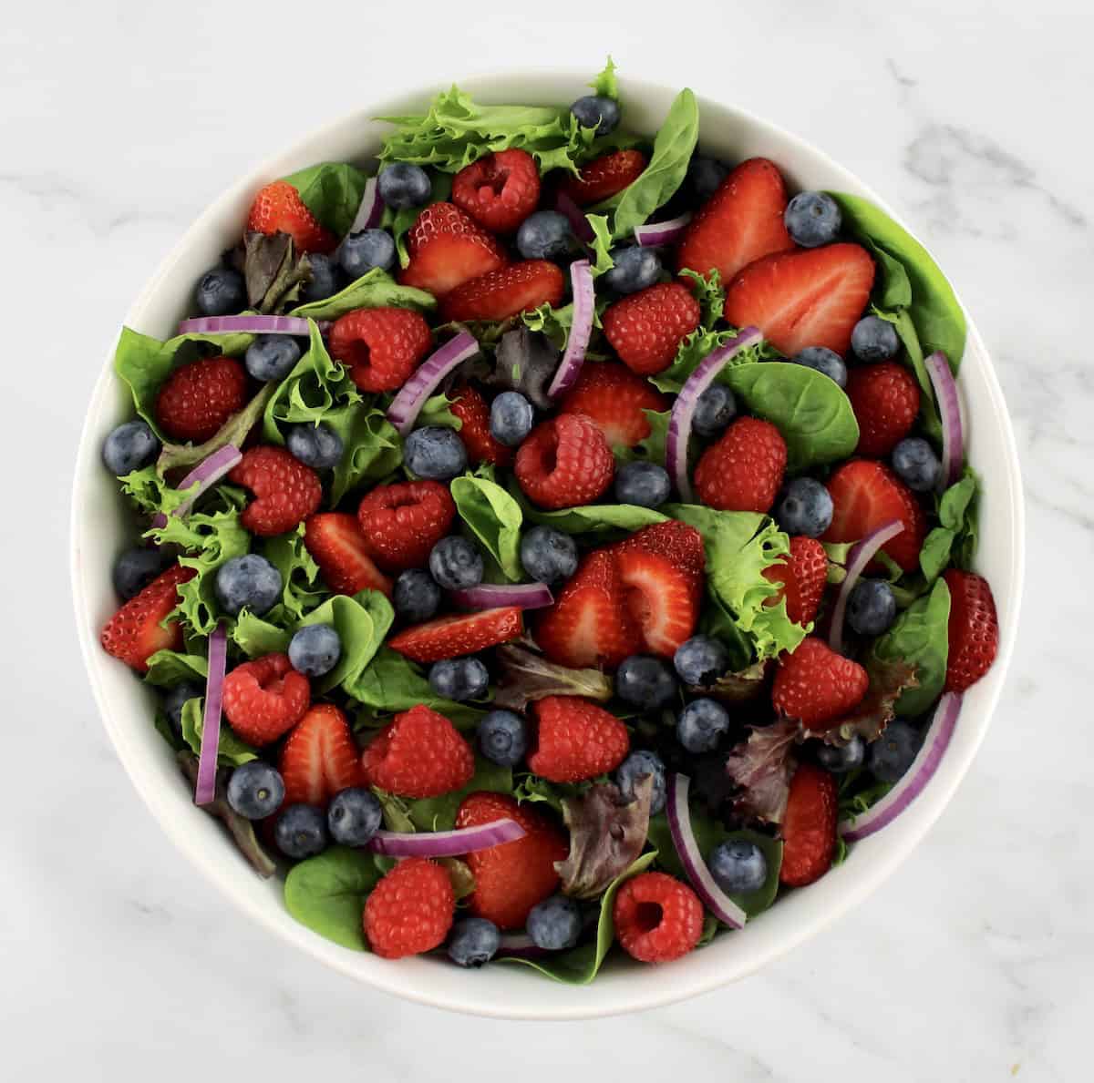 Triple Berry Salad in white bowl without dressing